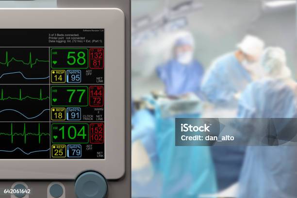 Intensive Care Unit Monitor And Ongoing Surgery In Background Stock Photo - Download Image Now