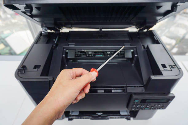 engineer with screwdriver for printer maintenance stock photo