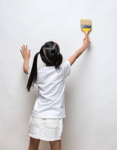 istock Little girl drawing something using painting brush 642075288