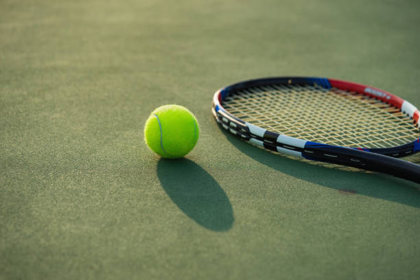 istock Tennis ball and racket under late evening sunlight 642077116