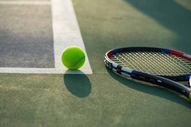 istock Tennis ball and racket under late evening sunlight 642079562