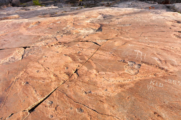 istock Modern vandal inscriptions over ancient petroglyphs carved on granite 642079620
