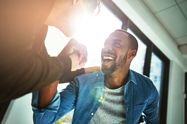 When hard work becomes success Low angle shot of two young businessmen celebrating a victory in the office punching the air stock pictures, royalty-free photos & images