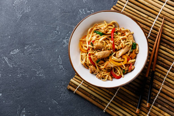 udon salteados fideos con pollo en tazón - wok fotografías e imágenes de stock