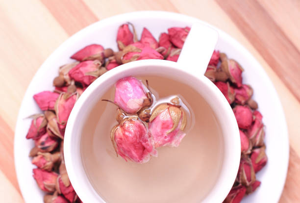 Dried roses and a cup of tea Dried roses and a cup of tea on a wooden background pink tea stock pictures, royalty-free photos & images