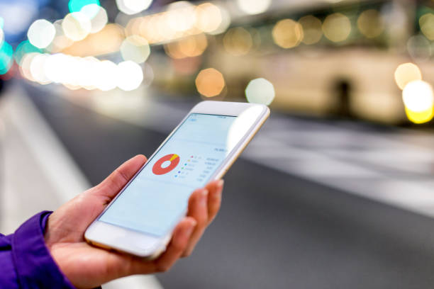 istock hand holds mobile phone on city street 642104154