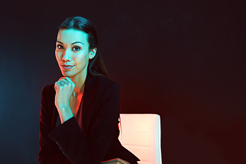 Portrait of a young businesswoman posing against a dark background