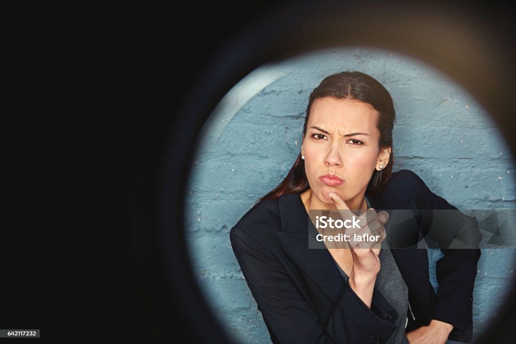 Don't even think of crossing me Portrait of a businesswoman posing against a brick wall with a peephole effect Adult Stock Photo