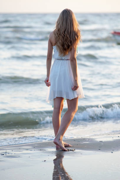 istock Woman walking on the beach 642120934
