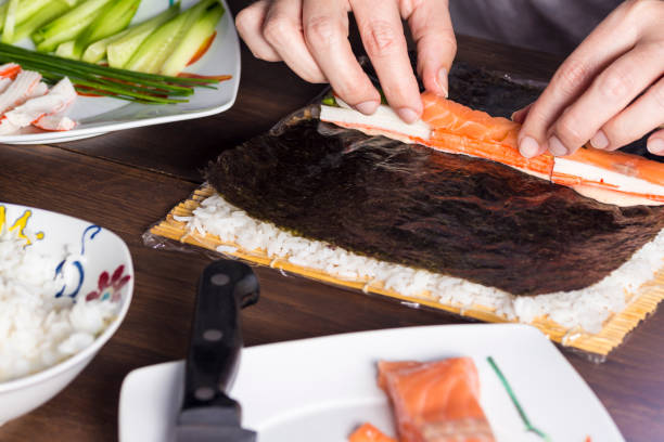istock Woman making at home Japanese sushi rolls. 642173552