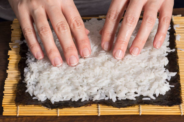 istock Woman making at home Japanese sushi rolls. 642173566