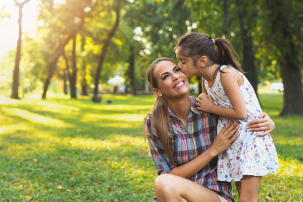 istock Mother and daughter outdoors playing, kissing and hugging 642179292