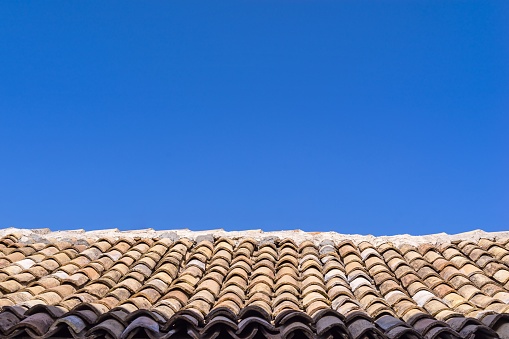 roof from an old tile against a blue clear sky