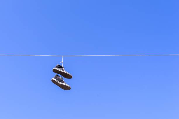 istock old gym shoes on a wire against the blue sky 642198780