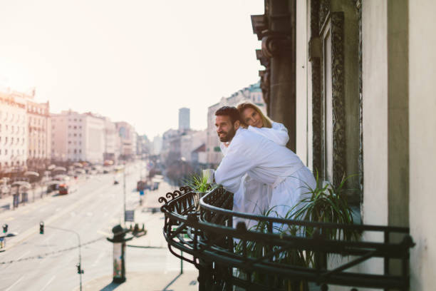 istock Couple in bathrobes drinking coffee on hotel balcony 642205610