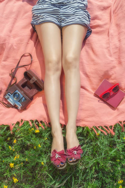 istock Girl's legs on a blanket with retro camera. 642214080