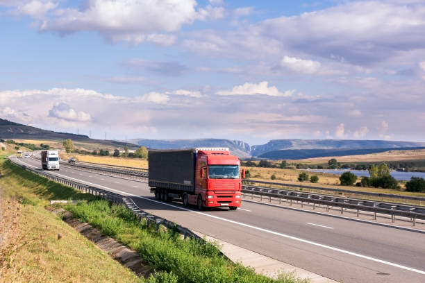 istock Red truck carrying cargo on the highway 642236274