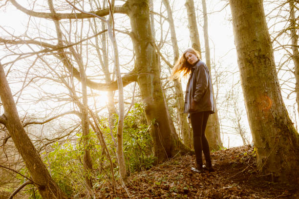 istock Beautiful young woman in black walking by a river 642246106