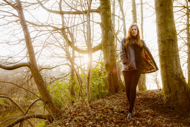 istock Beautiful young woman in black walking by a river 642246782