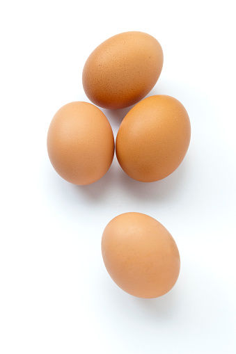 Vertical shot of four brown organic eggs isolated on white background. DSRL studio photo taken with Canon EOS 5D Mk II and Canon EF 100mm f/2.8L Macro IS USM
