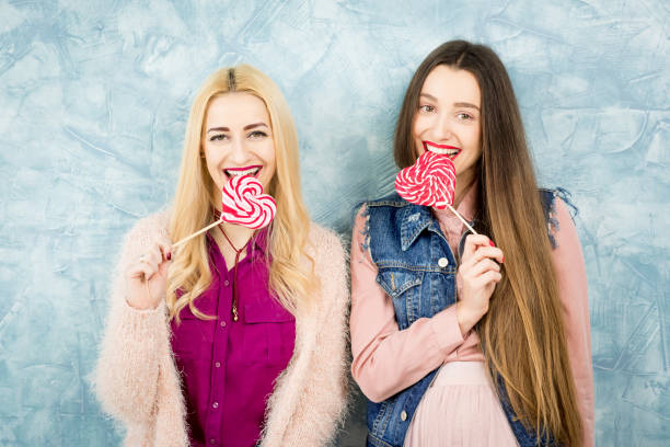 istock Female friends with candy on the blue background 642253530