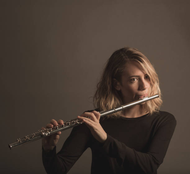 istock Young Woman Playing a Flute 642254592