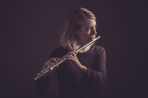 A young woman playing a flute (stock image)