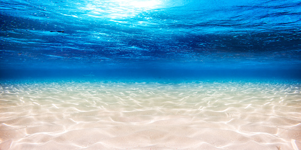 Fondo de arena bajo el agua azul del océano photo