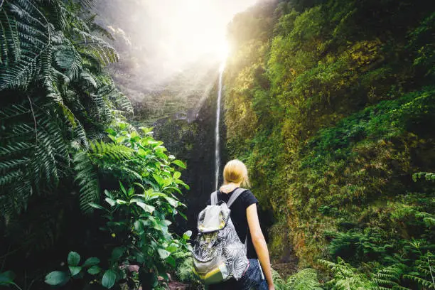 Young Woman enjoying the waterfall Caldeirão Verde while hiking on Madeira Island.