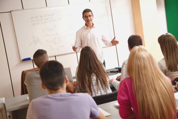 istock Smiling teacher giving lecture to students in classroom. 642279480