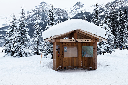 Lake louise,Alberta,Canada - January 27,2017:Winter landscape with snow and a  wooden information chalet providing maps with hiking trails and other information, at the entrance of Lake Louise in Banff National Park.