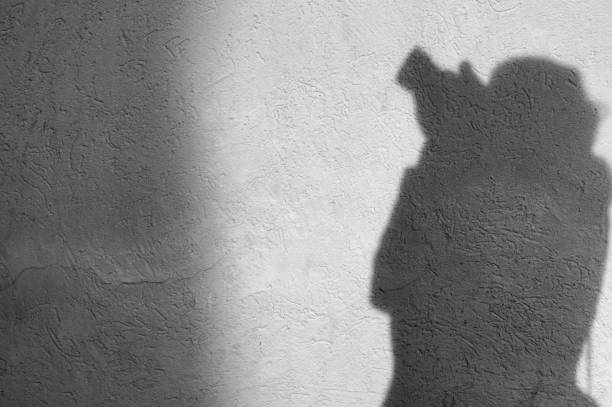 istock Shadow of unrecognizable,unknown photographer on the white wall 642285494