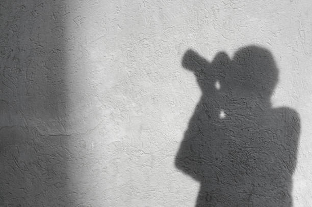 istock Shadow of unrecognizable,unknown photographer on the white wall 642285500
