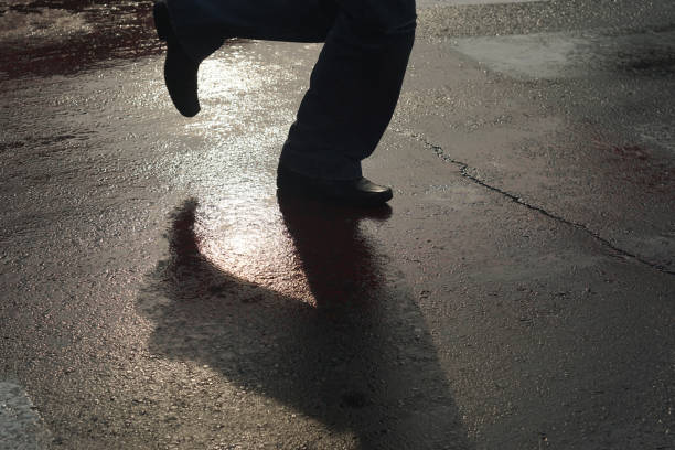 istock Shadow of running person at pedestrian crossing - Back light 642285518