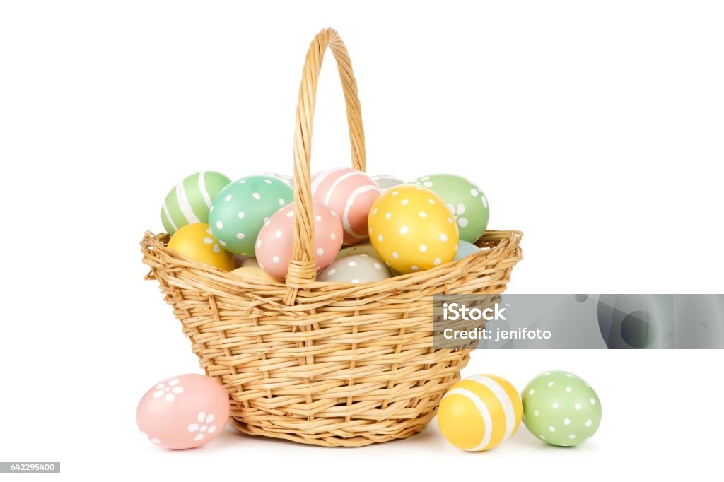 Easter basket filled with Easter Eggs over white Easter basket filled with hand painted pastel Easter Eggs over a white background Easter Egg Stock Photo