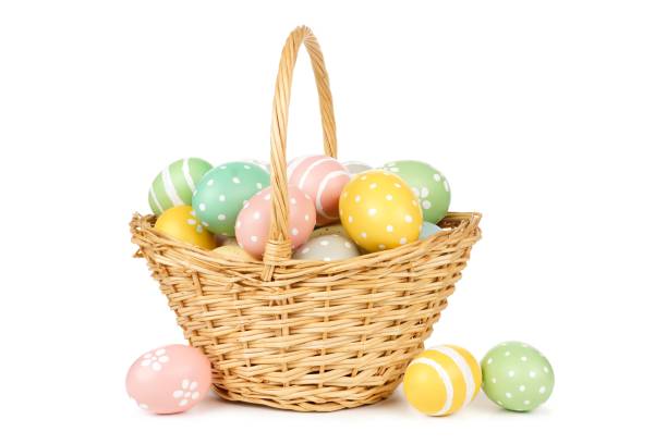 Easter basket filled with Easter Eggs over white Easter basket filled with hand painted pastel Easter Eggs over a white background basket stock pictures, royalty-free photos & images