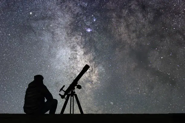 Photo of Man with astronomy  telescope looking at the stars.