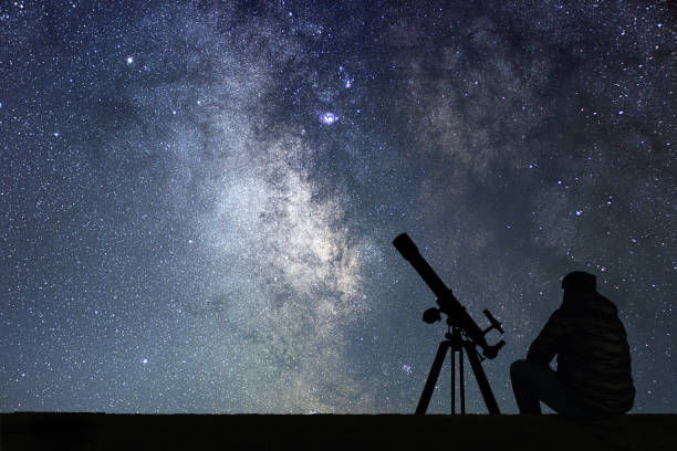 istock Man with astronomy  telescope looking at the stars. 642298368