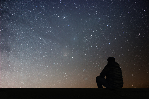 Man looking at the stars. Alone man looking at starry sky. Night sky.