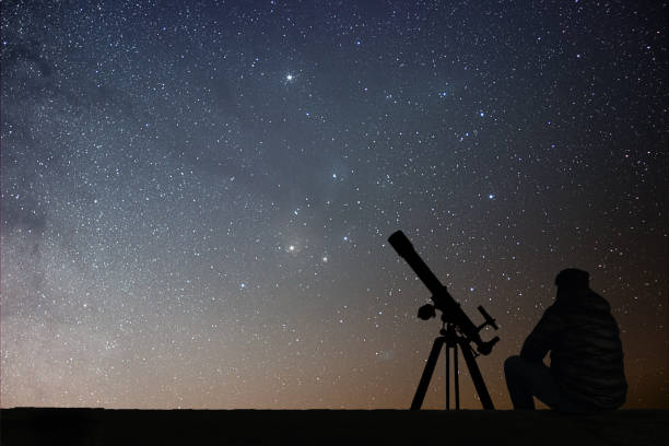 istock Man with astronomy  telescope looking at the stars. 642299124