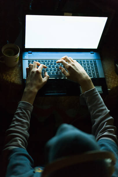 istock Hacker in hood and headphones working on laptop 642304452