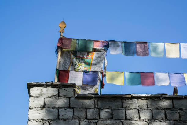 bandeiras de oração multicoloridos na aldeia de skiu, markha valley - tibetan script fotos - fotografias e filmes do acervo