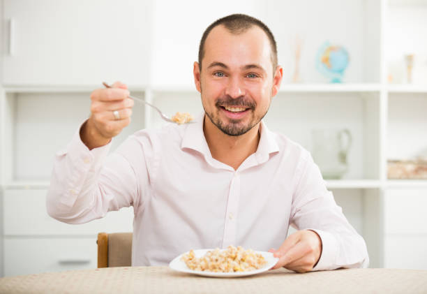 istock Positive young man eating porridge 642308252