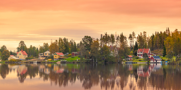 A small country village by a calm lake in Dalarna, Sweden.