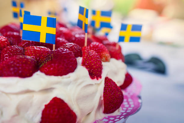 Strawberry cake A strawberry cake decorated with swedish flags for a summer solstice celebration. sweden flag stock pictures, royalty-free photos & images