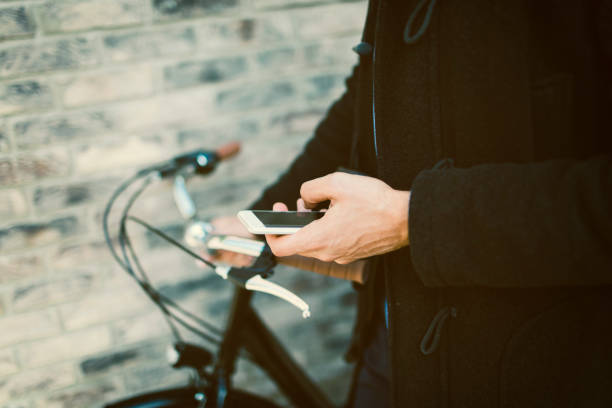 istock Businessman riding bicycle and using smart phone outdoors 642327318