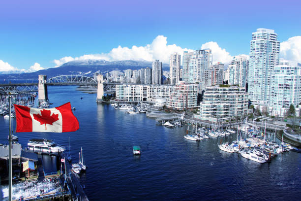 Vancouver Canada Canadian flag in front of view of False Creek and the Burrard street bridge in Vancouver, Canada. vancouver canada stock pictures, royalty-free photos & images