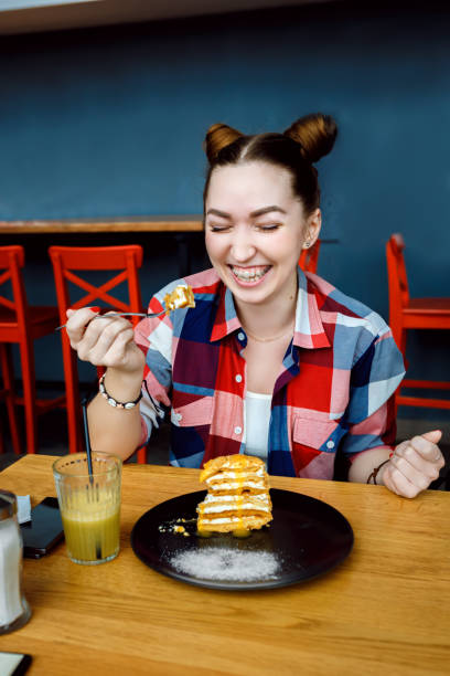 istock beatiful young woman eat desert in caffe 642336854