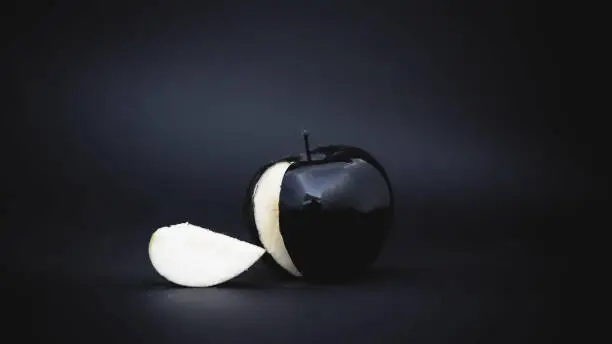 Photo of sliced black apple on a background