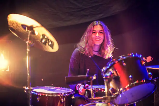 Young female drummer playing in the studio